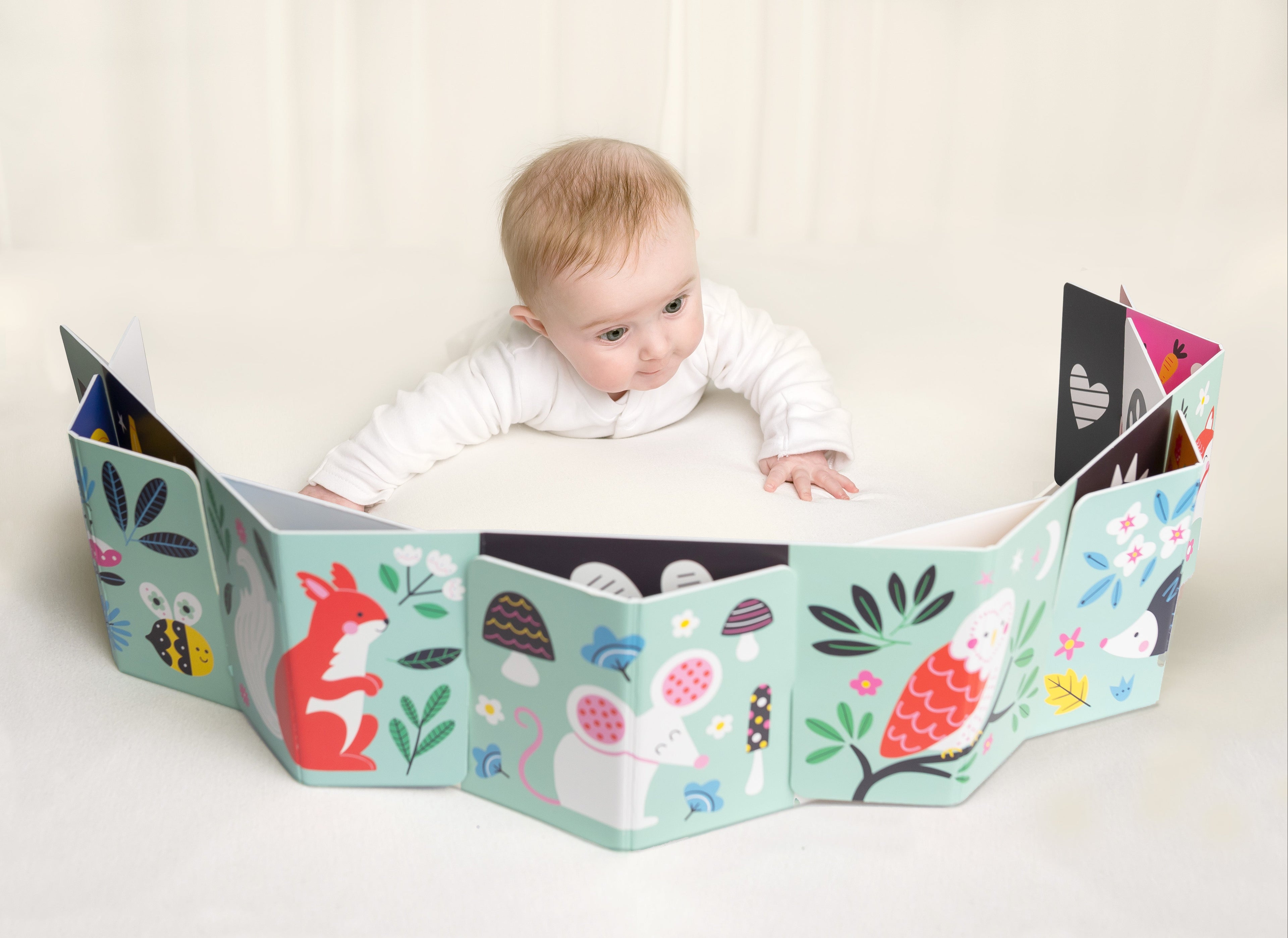Baby doing tummy-time with a baby sensory arch